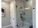 Modern walk-in shower with sleek tile work, glass door, and matte black fixtures at 26388 N 77Th Dr, Peoria, AZ 85383