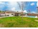 Expansive backyard featuring green grass, a covered patio, a pool, and mature trees at 2975 E Tulsa St, Gilbert, AZ 85295