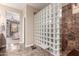 Modern bathroom featuring a glass block shower, marble tile and access to the main bedroom at 3143 N Evergreen St, Buckeye, AZ 85396