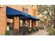 Ciao Grazie pizzeria boasts an inviting exterior with blue awnings, outdoor seating, and lush plants at 3143 N Evergreen St, Buckeye, AZ 85396