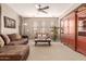 Spacious living area with plush seating, a ceiling fan, and large windows for natural light at 3143 N Evergreen St, Buckeye, AZ 85396
