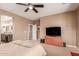 Main bedroom featuring carpet floors, an ensuite bathroom, and large television at 3143 N Evergreen St, Buckeye, AZ 85396