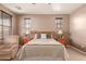 Bedroom featuring a bed with neutral tones, a cozy chair, and two windows at 3143 N Evergreen St, Buckeye, AZ 85396