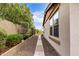 Side yard featuring a walkway and bushes along the house at 3143 N Evergreen St, Buckeye, AZ 85396