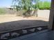 Backyard of the property featuring a large, open dirt area and block wall fencing at 32020 N 23Rd Ave, Phoenix, AZ 85085
