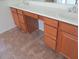 Bathroom vanity with oak cabinets, a white countertop with dual sinks and tile flooring at 32020 N 23Rd Ave, Phoenix, AZ 85085