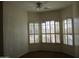 Well-lit bedroom with light color paint, ceiling fan, and three sunny windows with shutters at 32020 N 23Rd Ave, Phoenix, AZ 85085