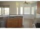 A kitchen with stainless steel sink, oak cabinets and tile flooring, providing functionality and style at 32020 N 23Rd Ave, Phoenix, AZ 85085