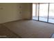 Open floor plan with sliding glass door to the patio, carpet floors and light color paint at 32020 N 23Rd Ave, Phoenix, AZ 85085