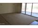 A spacious living room with carpet and large sliding glass doors leading to an outdoor space at 32020 N 23Rd Ave, Phoenix, AZ 85085