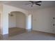 Open concept living room with a ceiling fan, neutral walls, carpet and arched doorways at 32020 N 23Rd Ave, Phoenix, AZ 85085