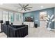 Cozy living room with a large television, tile flooring, a ceiling fan, and a dark, comfortable sofa at 3309 S 173Rd Ln, Goodyear, AZ 85338