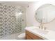 Updated bathroom with decorative tile shower, modern vanity, and round mirror at 4201 E Camelback Rd # 28, Phoenix, AZ 85018