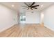 Spacious living room with wood-look floors, white walls, ceiling fan, and a patio view at 4201 E Camelback Rd # 28, Phoenix, AZ 85018