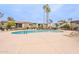 Community pool surrounded by lounge chairs with palm trees in the background on a clear day at 4201 E Camelback Rd # 28, Phoenix, AZ 85018