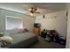 Bedroom features a ceiling fan, window, and carpeted floors at 4231 N 69Th Ln # 1325, Phoenix, AZ 85033