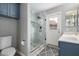 Modern bathroom with marble walk-in shower, updated fixtures, and blue vanity at 4558 E Rock Wren Rd, Phoenix, AZ 85044