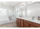 Bathroom featuring double sinks, wood cabinets, a glass shower, a tub, and tile flooring at 4727 S Watauga Dr, Gilbert, AZ 85297