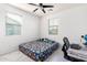 Cozy bedroom with a patterned bedspread, a modern fan, and two windows allowing natural light at 4727 S Watauga Dr, Gilbert, AZ 85297