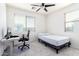 Well-lit bedroom with desk and a bed with patterned bedding, complemented by a modern ceiling fan at 4727 S Watauga Dr, Gilbert, AZ 85297