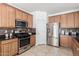 Well-equipped kitchen featuring stainless steel appliances, granite countertops, tiled backsplash, and tile flooring at 4727 S Watauga Dr, Gilbert, AZ 85297