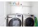 Bright laundry room featuring side-by-side Samsung washer and dryer and upper shelf for organized storage at 4727 S Watauga Dr, Gilbert, AZ 85297