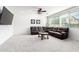 Spacious living room with neutral carpet, a plush brown sectional sofa, and large windows for ample natural light at 4727 S Watauga Dr, Gilbert, AZ 85297