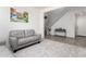 Cozy living room featuring neutral carpet, a comfortable gray sofa, and a staircase in a bright, open layout at 4727 S Watauga Dr, Gilbert, AZ 85297