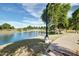 A view of the community pond and walking trail lined with lush green trees and grass at 4727 S Watauga Dr, Gilbert, AZ 85297