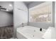 Bathroom with a large soaking tub, window with blinds, and neutral paint at 5025 N 85Th Dr, Glendale, AZ 85305