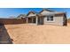 View of the large, unfinished backyard showcasing the covered patio and block wall at 5359 W Las Palmaritas Dr, Glendale, AZ 85302