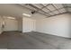 Spacious three car garage features high ceilings, updated lighting, and a finished concrete floor at 5359 W Las Palmaritas Dr, Glendale, AZ 85302