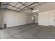 View of the large three car garage with high ceilings, lights, and a Personal door at 5359 W Las Palmaritas Dr, Glendale, AZ 85302