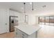 Spacious kitchen with a large center island, stainless steel refrigerator, and an open layout to the living area at 5359 W Las Palmaritas Dr, Glendale, AZ 85302