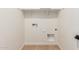 Empty laundry room with tile floors, white walls, shelving, and washer/dryer hookups at 5359 W Las Palmaritas Dr, Glendale, AZ 85302