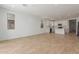 Open-concept living space with sleek flooring, showcasing the kitchen with white cabinetry and stainless appliances at 5359 W Las Palmaritas Dr, Glendale, AZ 85302