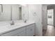 Bathroom featuring double sinks with chrome faucets, modern cabinets, and an oversized mirror at 5401 W Las Palmaritas Dr, Glendale, AZ 85302