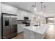 Bright kitchen with stainless appliances, white cabinets, gray backsplash, and open layout to the dining area at 5401 W Las Palmaritas Dr, Glendale, AZ 85302