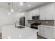 Modern kitchen with stainless steel appliances, white cabinets, quartz countertops, and pendant lighting at 5401 W Las Palmaritas Dr, Glendale, AZ 85302