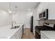 Bright, modern kitchen features white cabinets, stainless steel appliances, quartz countertops, and pendant lights at 5401 W Las Palmaritas Dr, Glendale, AZ 85302