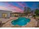 Aerial view of the backyard with pool, patio, and outdoor kitchen against a stunning sunset backdrop at 5650 E Presidio Rd, Scottsdale, AZ 85254