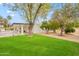 Spacious backyard with a pool, patio, grassy area, and lush mature landscaping at 5650 E Presidio Rd, Scottsdale, AZ 85254