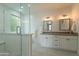 Bright bathroom featuring a double vanity, walk-in shower, and window for natural light at 5650 E Presidio Rd, Scottsdale, AZ 85254