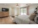 Bedroom featuring wood floors, TV on dresser, and access to backyard pool area at 5650 E Presidio Rd, Scottsdale, AZ 85254