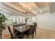 Inviting dining room with exposed beams, hardwood flooring, and decorative chandelier at 5650 E Presidio Rd, Scottsdale, AZ 85254