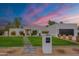 Contemporary home with a manicured lawn, modern address marker, and symmetrical landscaping at dusk at 5650 E Presidio Rd, Scottsdale, AZ 85254