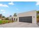 Modern home featuring a large garage door, manicured lawn, and decorative landscaping at 5650 E Presidio Rd, Scottsdale, AZ 85254