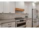 Kitchen features modern appliances, countertops, backsplash, and white cabinets with bronze accents at 5650 E Presidio Rd, Scottsdale, AZ 85254