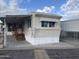 Exterior of manufactured home featuring covered porch, awning, and mature landscaping at 61 W Southern Ave # 25, Mesa, AZ 85210