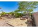 Inviting backyard with a stone fire pit, built-in seating, and a beautifully landscaped area at 6887 S Teresa Dr, Chandler, AZ 85249
